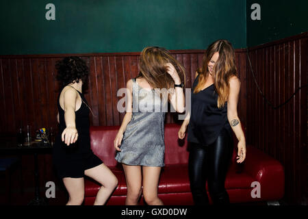 Three adult female friends dancing in club on night Stock Photo
