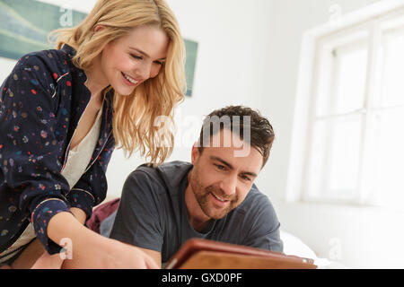 Couple using digital tablet smiling Stock Photo
