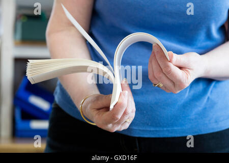 Mid section of female worker checking paper in printing press workshop Stock Photo