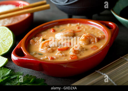 A bowl of delicious Thai red curry coconut shrimp soup with rice. Stock Photo