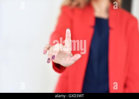The girl in the red jacket pushes finger virtual button -close-up Stock Photo