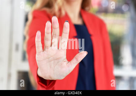 Girl in a red jacket makes stopping gesture open hand - close-up Stock Photo