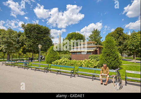 Vienna, Austria - August 14, 2016: An unidentified man reading newspaper in Volksgarten (People's Garden). Stock Photo