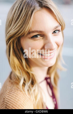 Portrait of young woman, blonde hair, smiling, close-up Stock Photo