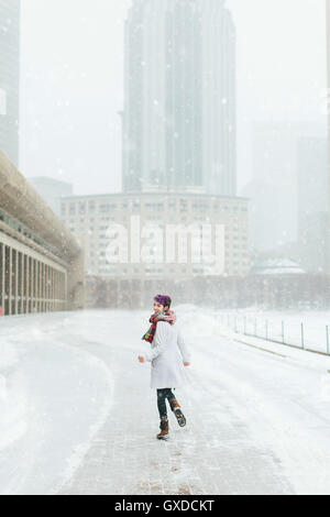 Young woman in front of the Christian Science Centre and Prudential building with snow, Boston, Massachusetts, USA Stock Photo