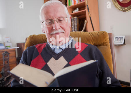 Senior man reading book at home Stock Photo