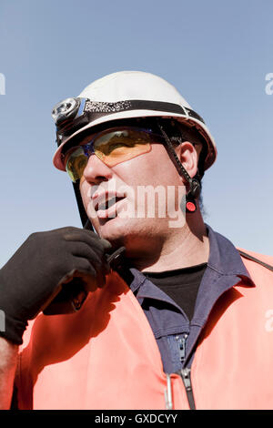 Engineer using walkie talkie on oil rig Stock Photo
