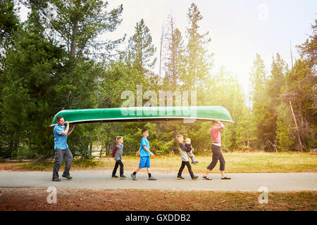 Family with four children carrying canoe, Grand Teton National Park, Wyoming, USA