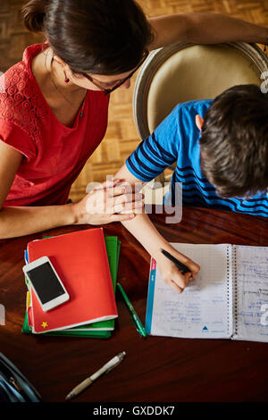 High angle view of mother at dining table helping son with homework Stock Photo