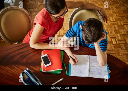 High angle view of mother at dining table helping son with homework Stock Photo