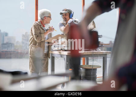 Carpenters having discussion in furniture making workshop Stock Photo