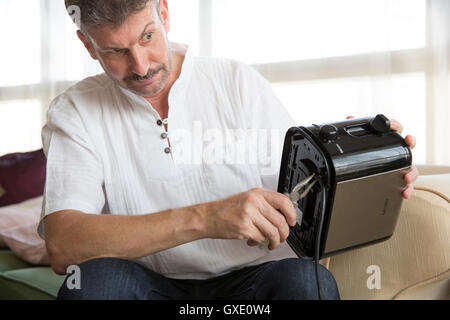 middle aged man is fixing a toaster Stock Photo