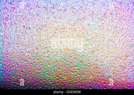Colorful beads of frozen water after a sleet storm create interesting ice patterns on the exterior metal finish of a silver auto Stock Photo