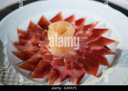 Decorative arrangement of iberian cured ham on plate. Selective focus point Stock Photo