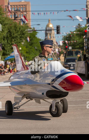 An Air Force officer rides in a miniature fighter jet during the Cheyenne Frontier Days parade through the state capital July 23, 2015 in Cheyenne, Wyoming. Frontier Days celebrates the cowboy traditions of the west with a rodeo, parade and fair. Stock Photo