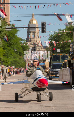 An Air Force officer rides in a miniature fighter jet during the Cheyenne Frontier Days parade through the state capital July 23, 2015 in Cheyenne, Wyoming. Frontier Days celebrates the cowboy traditions of the west with a rodeo, parade and fair. Stock Photo