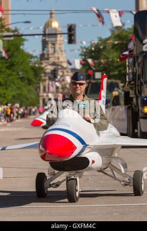 An Air Force officer rides in a miniature fighter jet during the Cheyenne Frontier Days parade through the state capital July 23, 2015 in Cheyenne, Wyoming. Frontier Days celebrates the cowboy traditions of the west with a rodeo, parade and fair. Stock Photo