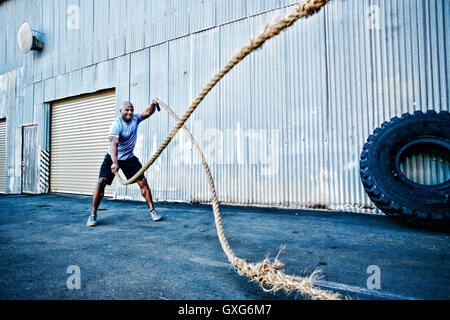 Black man working out with heavy ropes outdoors Stock Photo