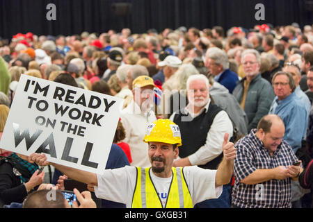 A supporter of Billionaire and GOP presidential candidate Donald Trump dressed as a construction worker waves a sign supporting the wall with Mexico during a rally February 19, 2016 in Myrtle Beach, South Carolina. The Republican primary vote in South Carolina takes place on Saturday, February 20th. Stock Photo