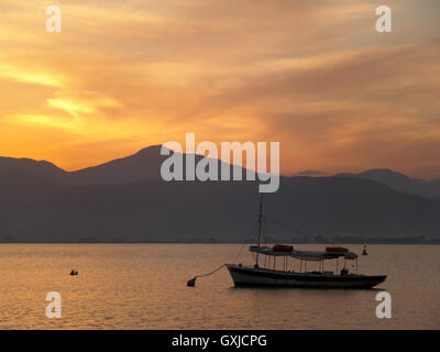 A Boat Floating on the Aegean Sea under Beautiful Golden Sky After Sunset , Nafplio, Greece Stock Photo