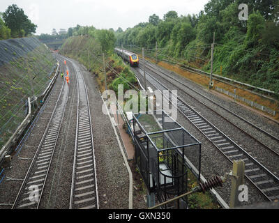 Hunton bridge near Watford, UK. 16th September, 2016. Railtracks showing rescue workers walking on track to attend the  Hunton Bridge landslide and derailmnt at Hunton Bridge tunnel. Also showing a moving train from London, Euston on the other railway line in wet weather. Credit:  Elizabeth Debenham/Alamy Live News Stock Photo
