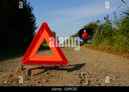 hazard warning triangle on country road warning of man with broken down vehicle ahead york yorkshire uk Stock Photo