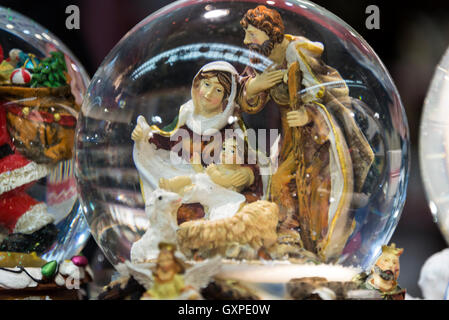 A large glass dome showing a nativity birth scene showing Mary & Joseph with baby Jesus in a crib  on sale at the Munich Christm Stock Photo