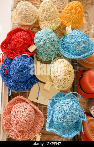 Homemade hats hanging out of shops Stock Photo