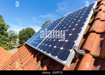 Row of blue solar panels  on orange roof Stock Photo