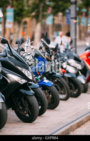 Motorbike, Motorcycle Scooters Parked In Row In City Street. Close Up Of Wheel Stock Photo