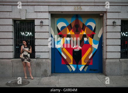 Woman looking at her cell phone in Little Italy, Manhattan Stock Photo
