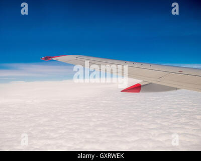 View through plane window with wing and clouds Stock Photo