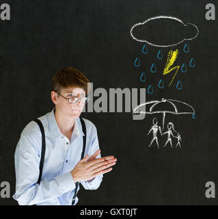 Insurance businessman protecting family from natural disaster on blackboard background Stock Photo