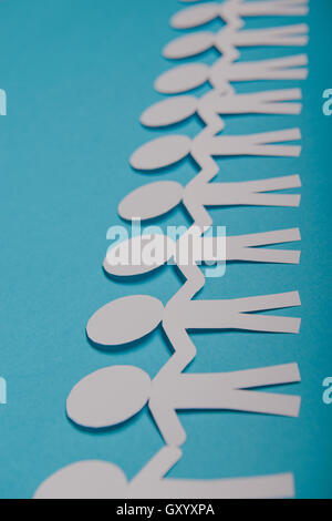 abstract paper people holding for hands on blue background Stock Photo