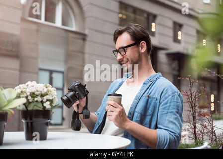 Attractive male photographer looking at the photos Stock Photo