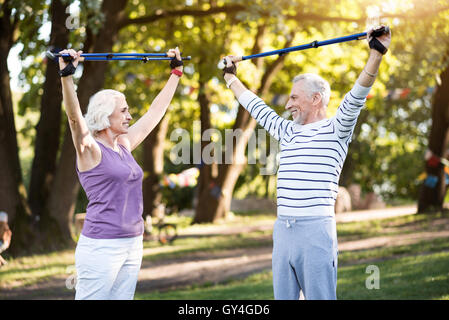 Good productive physical training of elderly couple in summer park Stock Photo