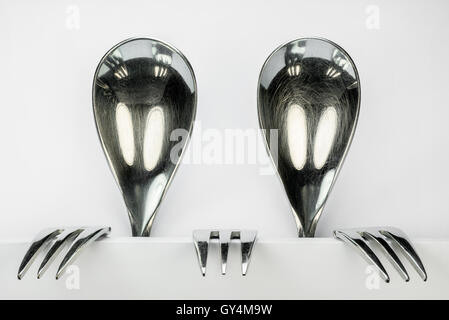 Metal spoons and three forks formed into two conceptual fantasy figures Stock Photo