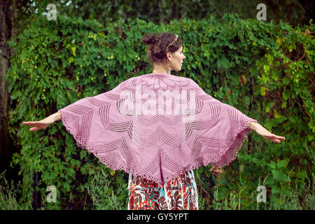 Romantic woman in crocheted plaid in nature Stock Photo