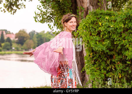 Romantic woman in crocheted plaid in nature Stock Photo