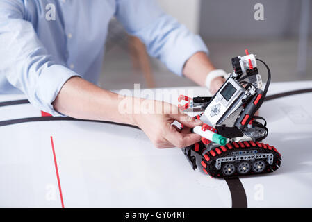 Small humanlike robot holding green marker Stock Photo