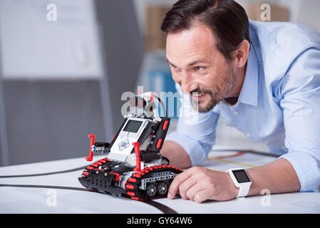 Middle-aged attractive man launching a robot Stock Photo