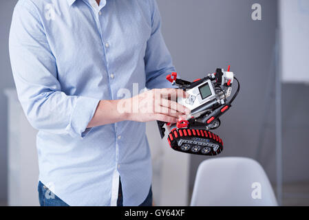 Man's fingers pressing buttons on a robot Stock Photo