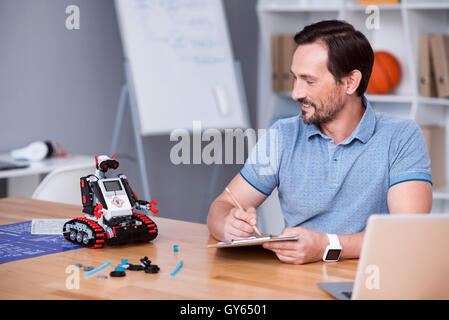 Positive mans sitting at the table Stock Photo