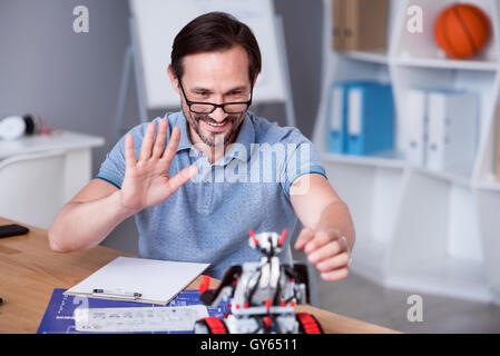 Positive engineer testing the robot Stock Photo - Alamy
