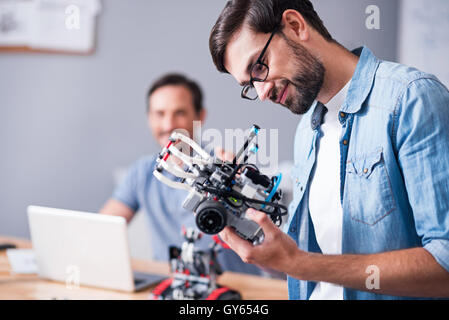 Cheerful man testing robot Stock Photo