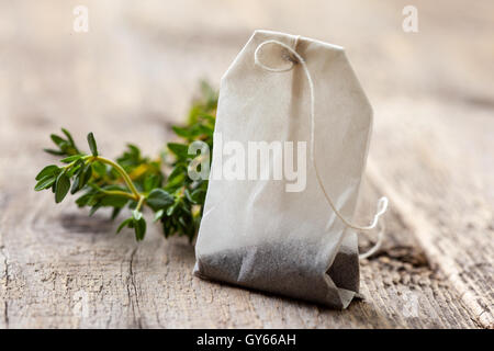 tea bag and fresh thyme on an old wooden background Stock Photo