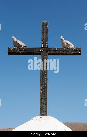 Fuerteventura: two pigeons on a wooden cross in Betancuria, the first town founded by Spanish colonizers in 1405 Stock Photo