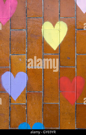 Colorful hearts painted on a brick pattern Stock Photo