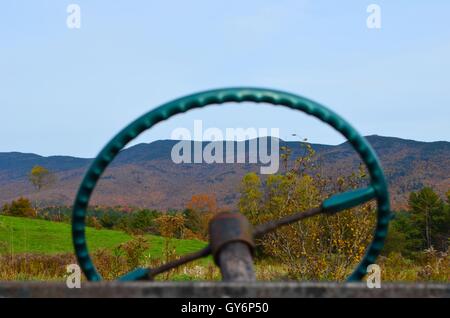 Looking through a vintage automobile wheel at autumn mountain landscape background Stock Photo