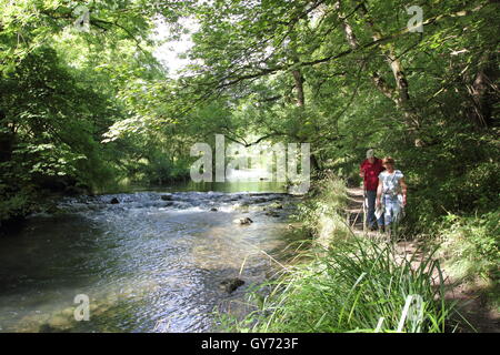 A man and woman on a beautiful riverside footpath by the Rive Wye in Chee Dale, Peak District National Park, Derbyshire Stock Photo